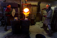 Marcel and Daniel pour molten bronze into the ceramic encasing for the James Martin sculpture